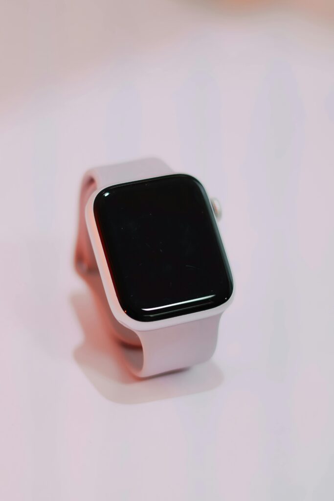 A sleek white smartwatch displayed on a plain surface with a minimalist style.